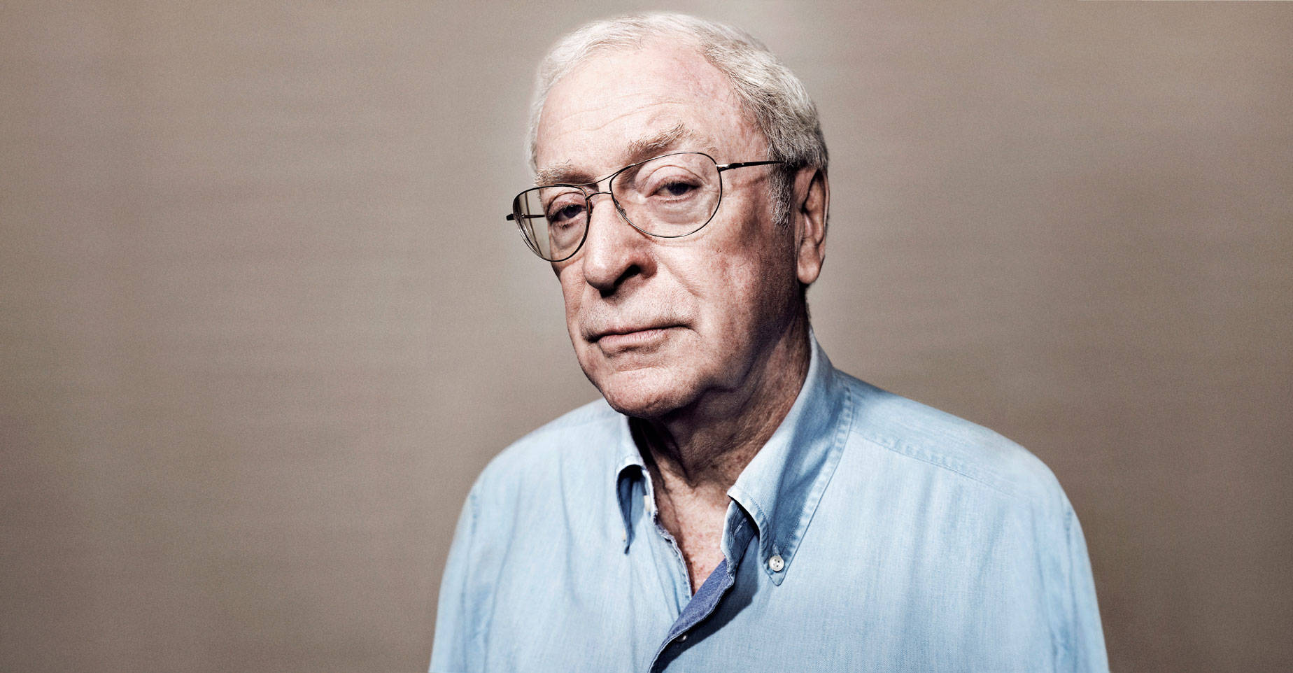 British Actor Michael Caine In Blue Shirt Portrait Background