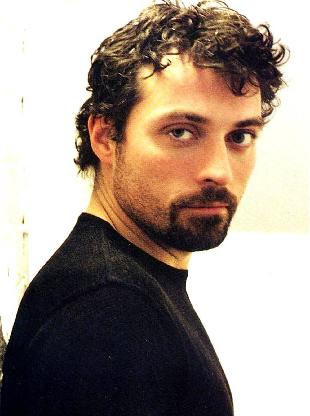 British Actor Rufus Sewell Posing With Curly Hair And Dark Beard Background