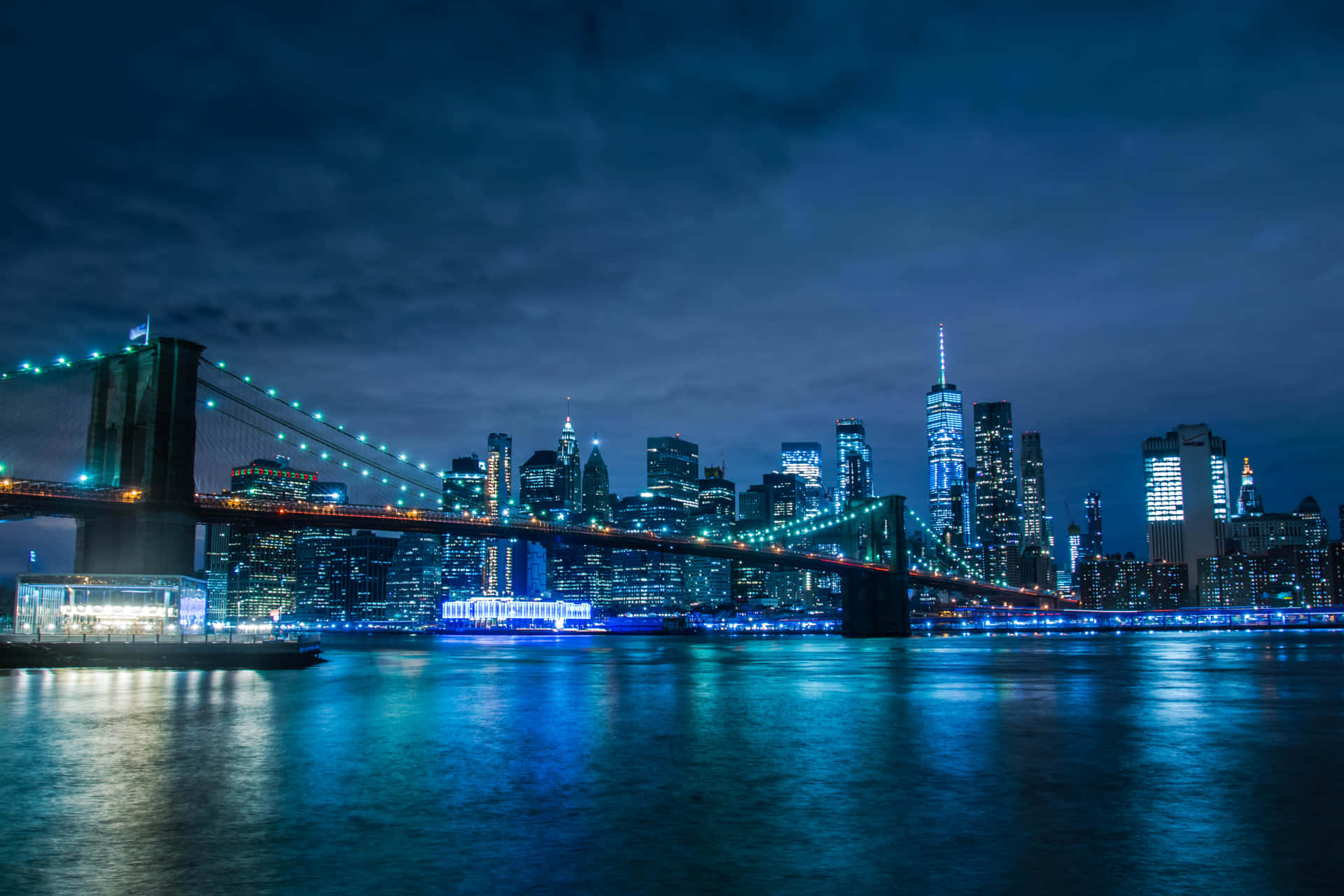 Brooklyn Bridge At Night With The City Lights Background