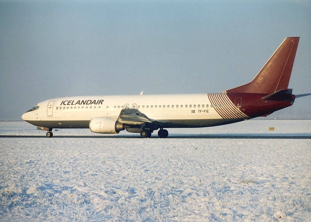 Brown And White Icelandair Plane In Snow Background