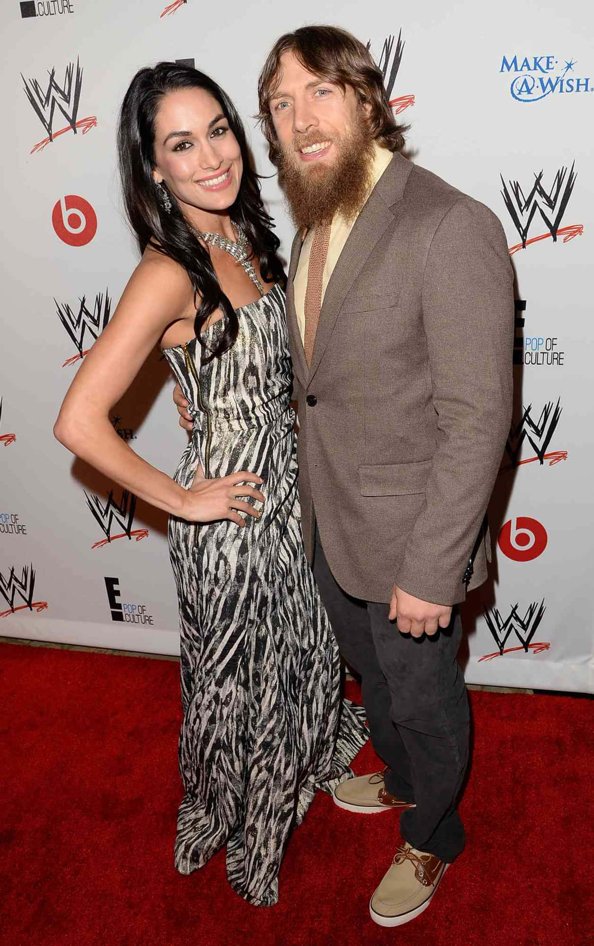 Bryan Danielson And Brie Bella Striking A Pose Together Background