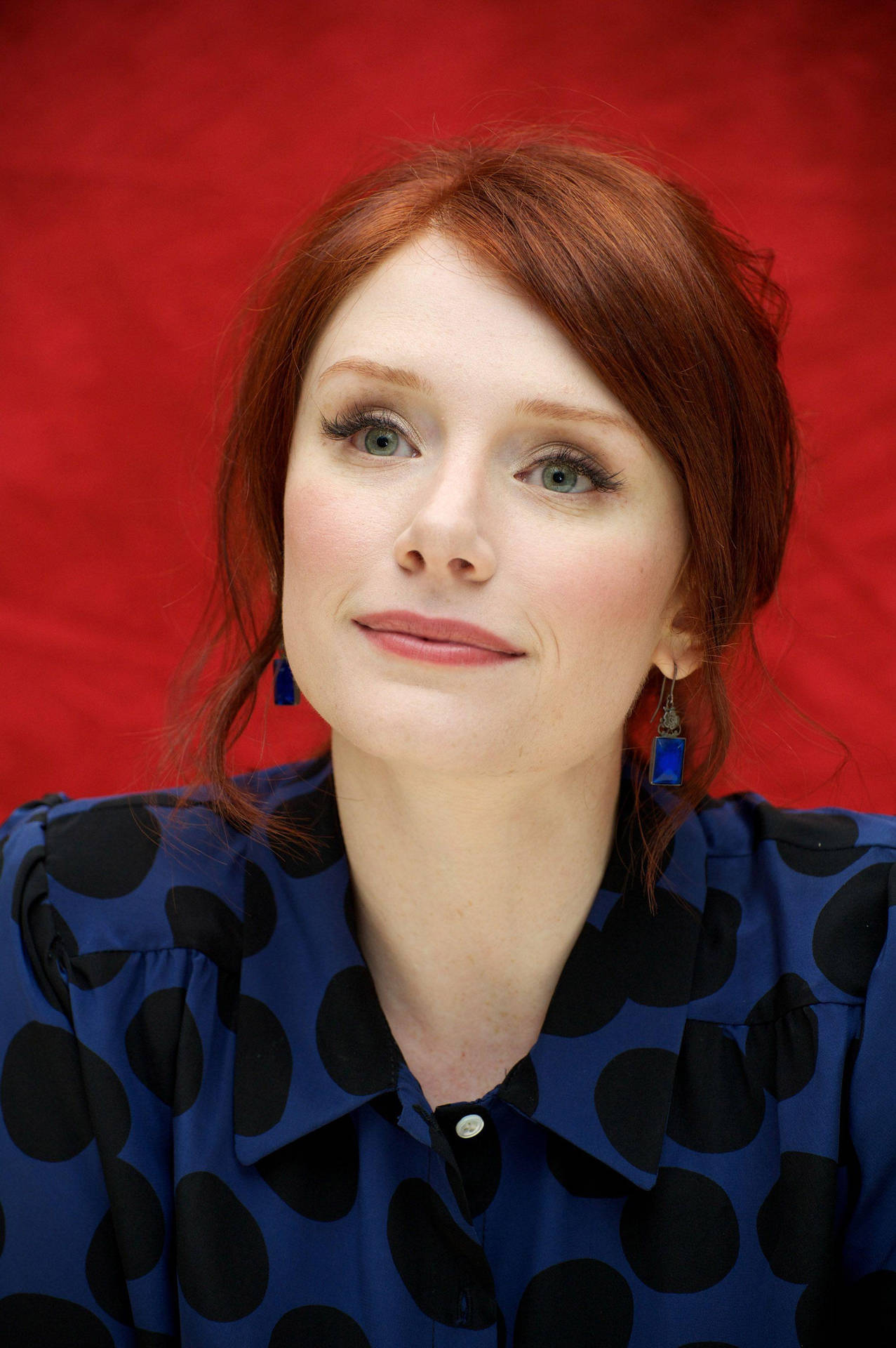 Bryce Dallas Howard In Blue Outfit On Red Background Background