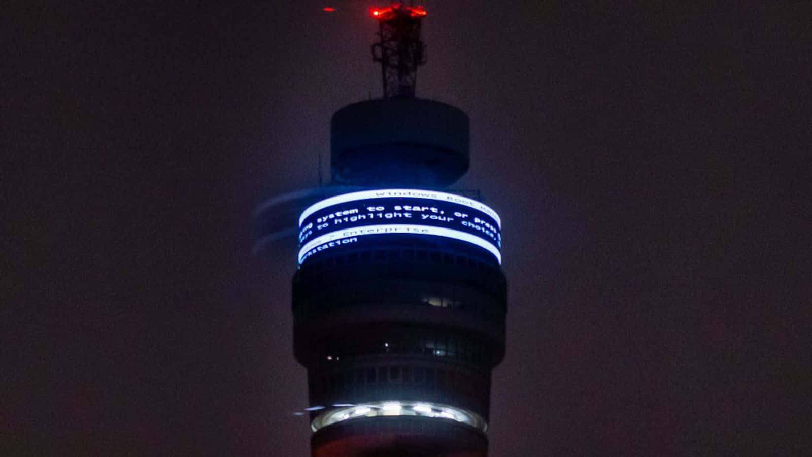 Bt Tower With Signs Lit Up Background