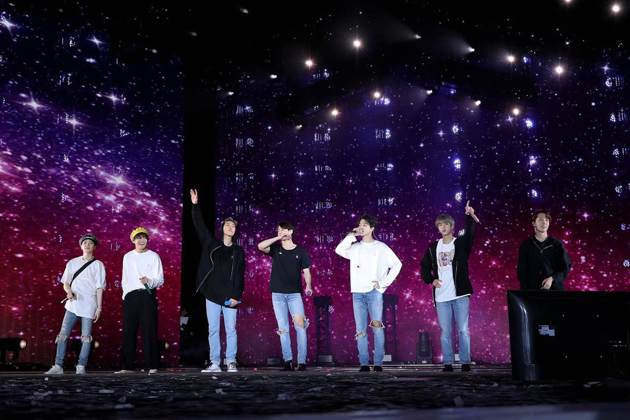 Bts Illuminating The Concert With Their Magnetic Performance Background