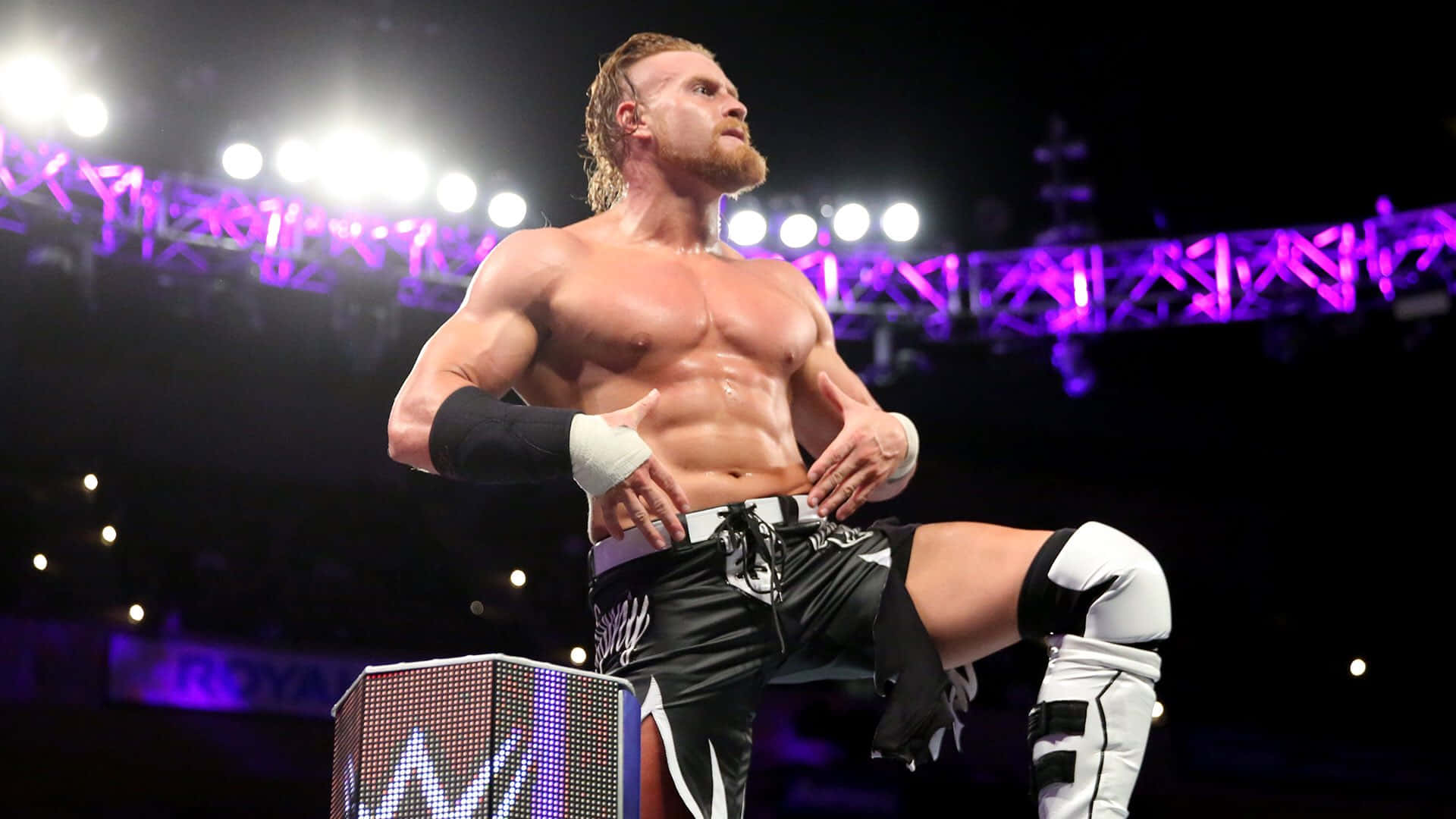 Buddy Murphy Striking A Powerful Pose At Wwe 205 Live Event. Background