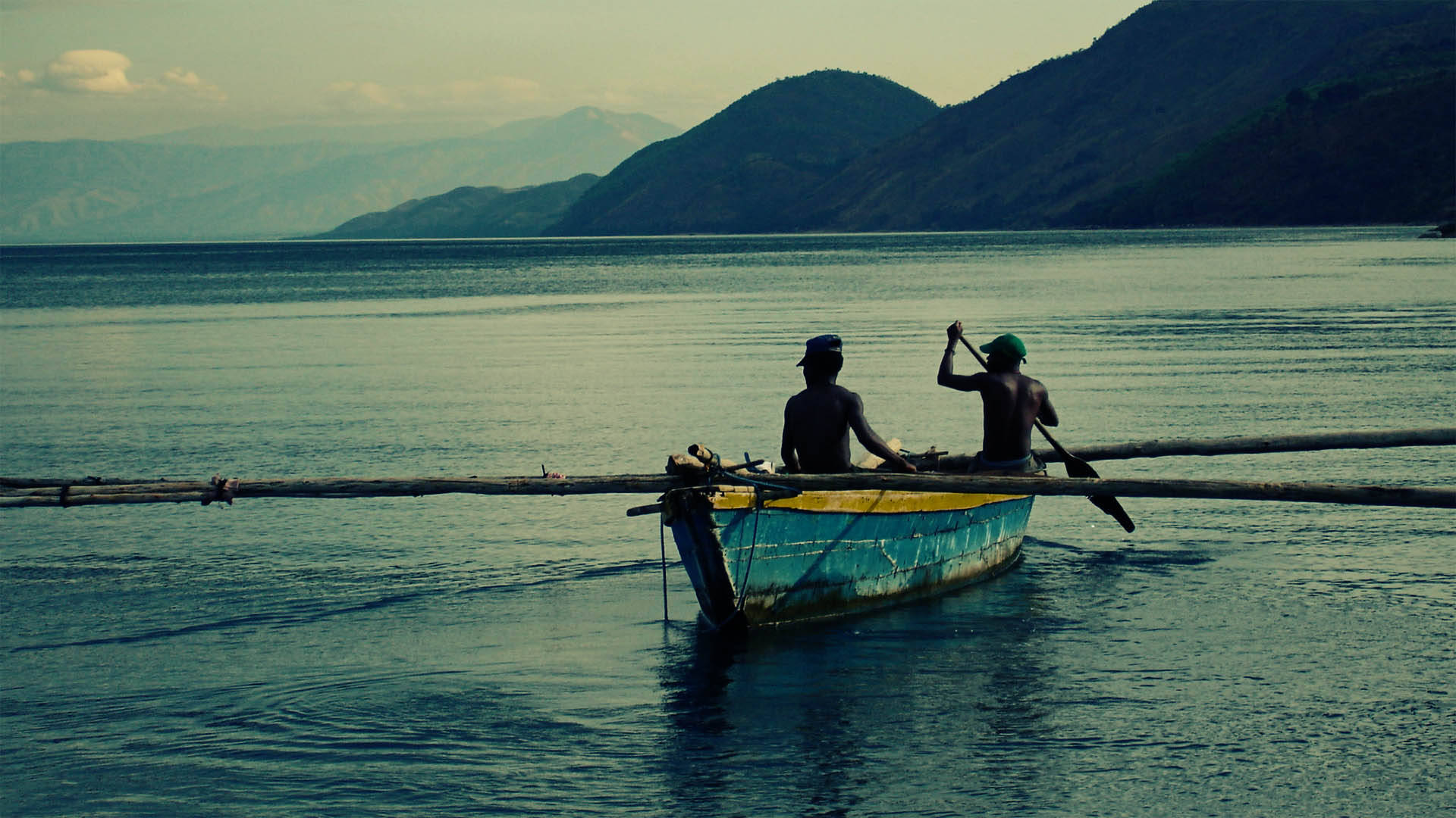 Burundi Fishermen Paddling A Traditional Canoe Background