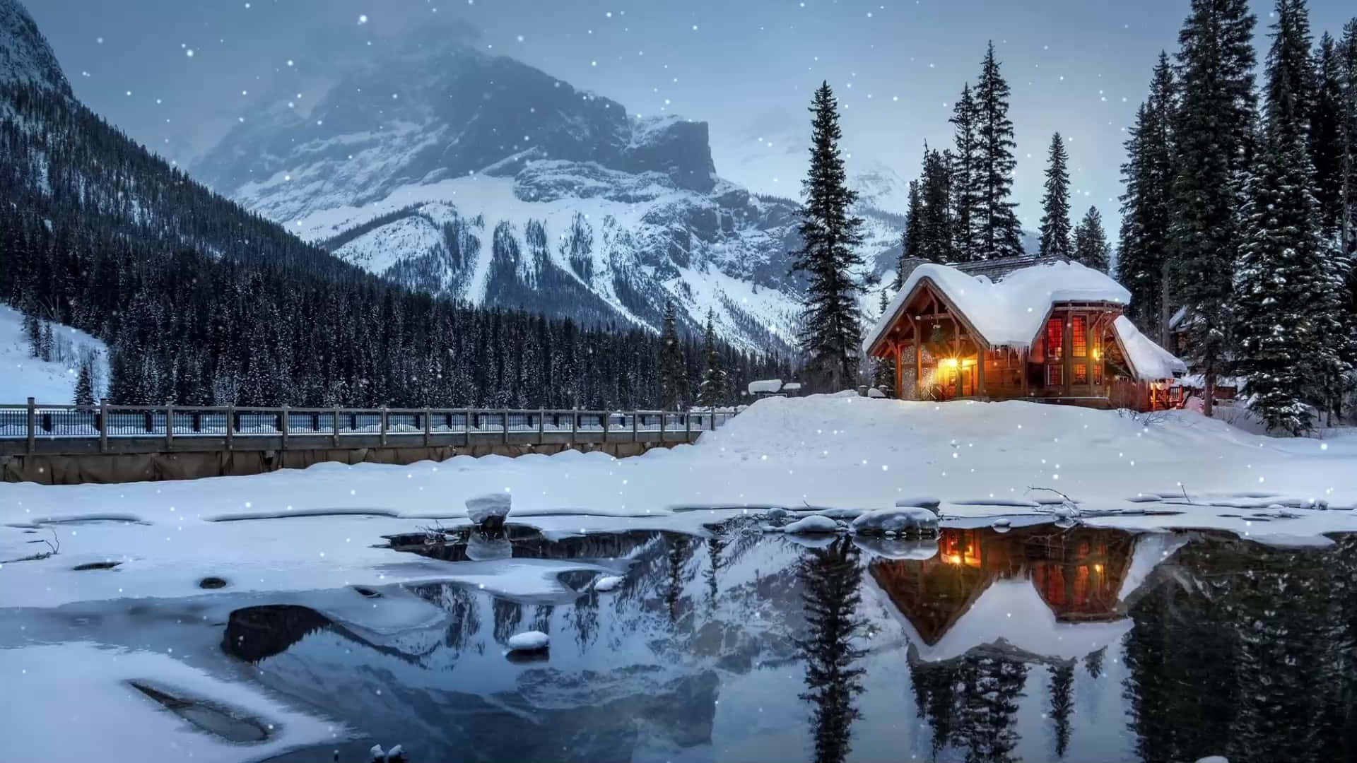 Cabin Covered In Snow By A Lake Background