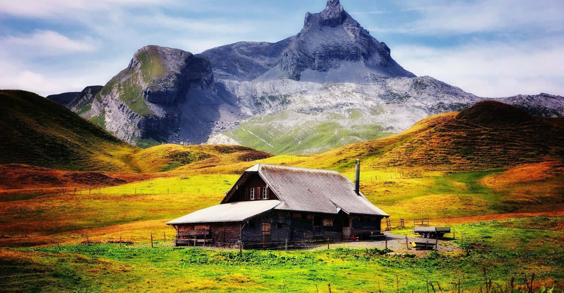 Cabin Overlooking A Snowy Mountain Background