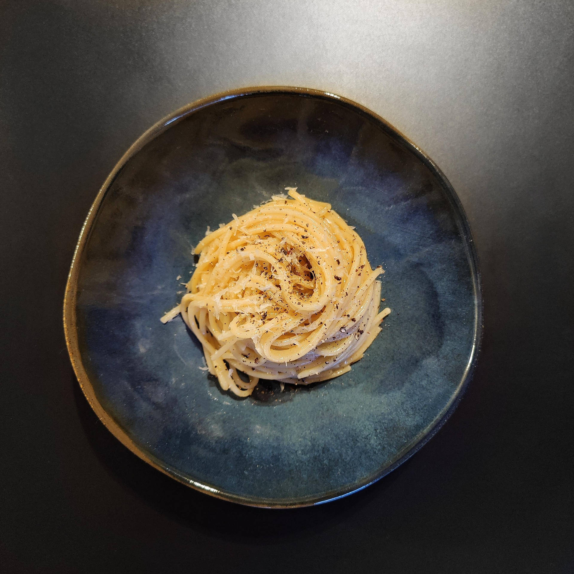 Cacio E Pepe On A Blue Plate Background