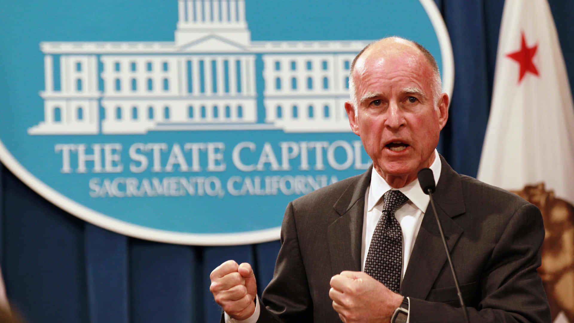 California Governor Jerry Brown Speaking At The State Capitol Background