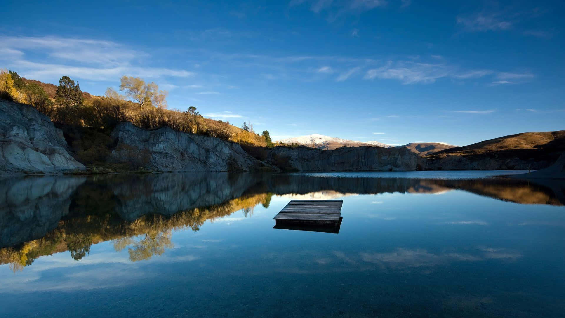 Calming Desktop Lake Surrounded By Mountain Background