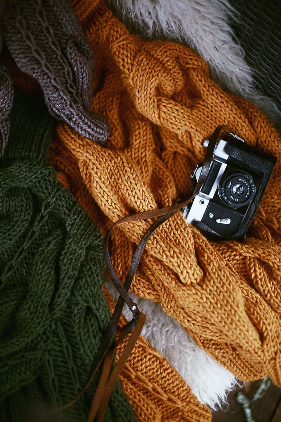 Camera On Top Of A Bronze Colored Knit Sweater Background