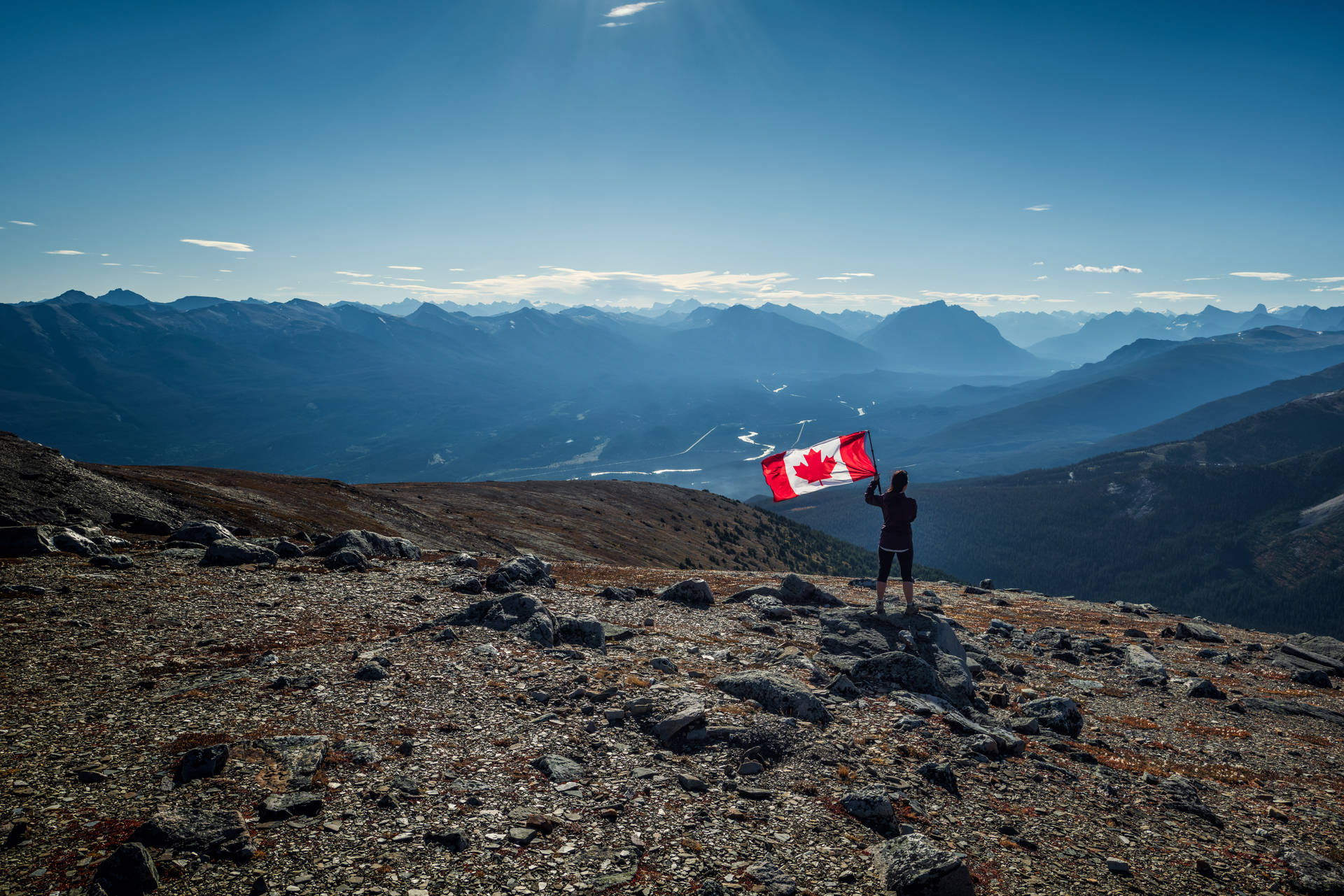 Canadian Flag And Person On Mountain