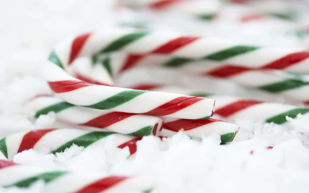 Candy Canes On A Snow Covered Surface Background