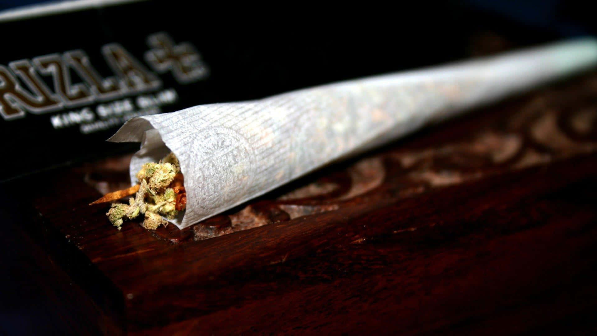 Cannabis Peeking Out From Joint Background