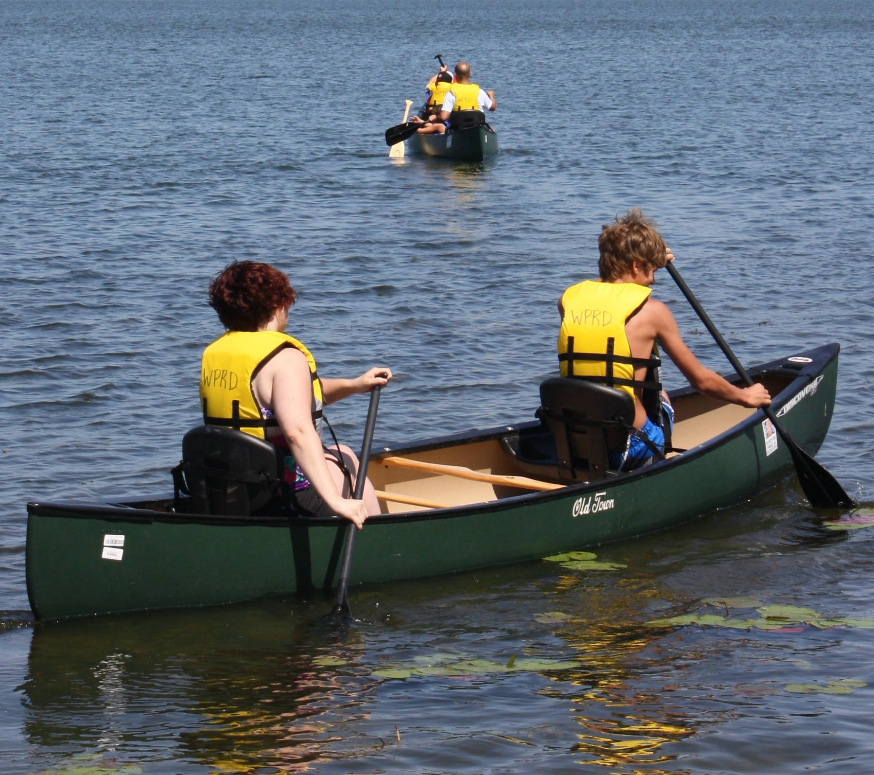 Canoeing In Yellow Life Jackets Background