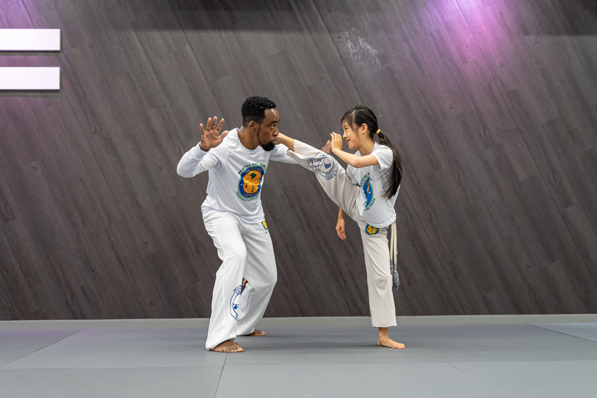 Capoeira Coach Teaching A Student Background