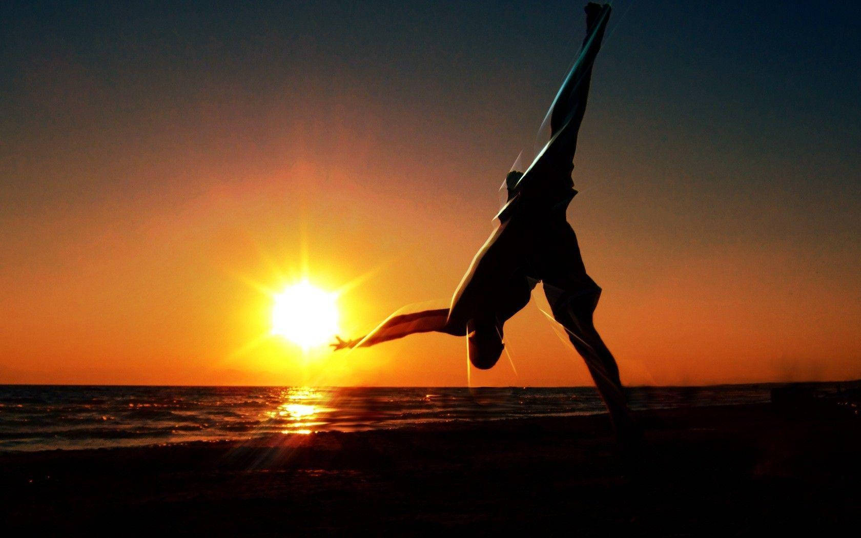 Capoeira Fighter Doing A Flip At Sunset Background