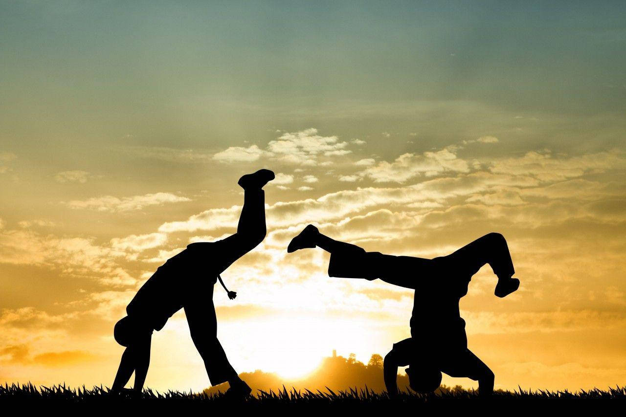 Capoeira Fighters During Sunset Background