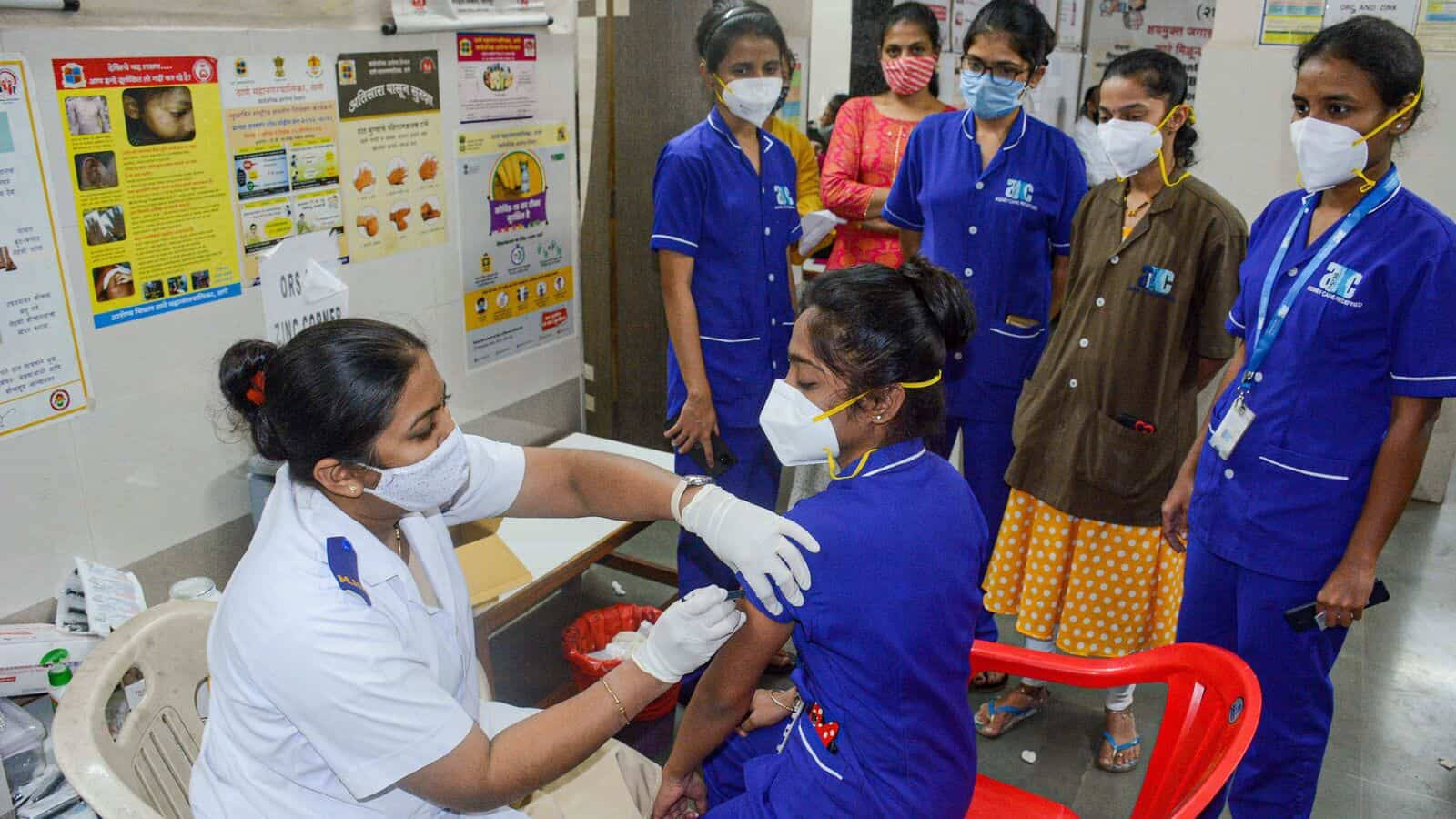 Caption: A Dedicated Nurse Administering Vaccines To Medical Students. Background