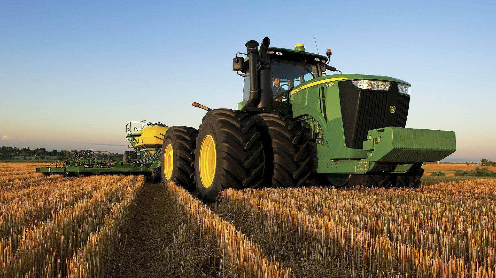 Caption: A Pristine John Deere 9r Series Tractor Standing Tall In A Grand Landscape. Background