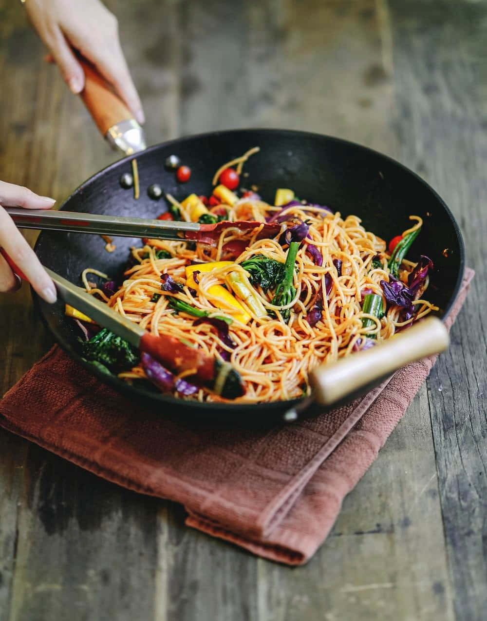 Caption: A Savory Stir-fry Chow Mein In A Wok Background