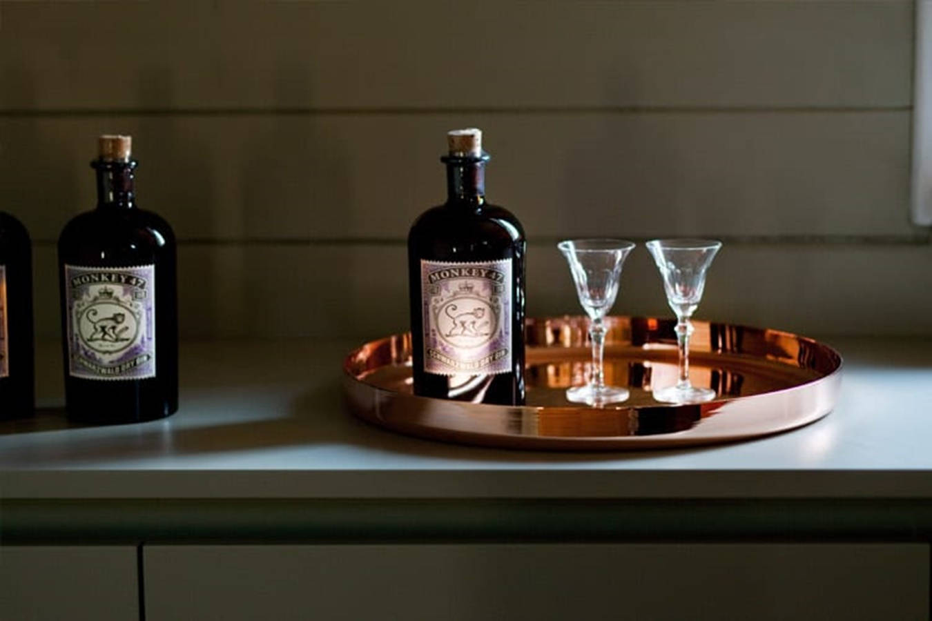 Caption: A Sophisticated Symmetry Of Monkey 47 Schwarzwald Dry Gin On Display Background