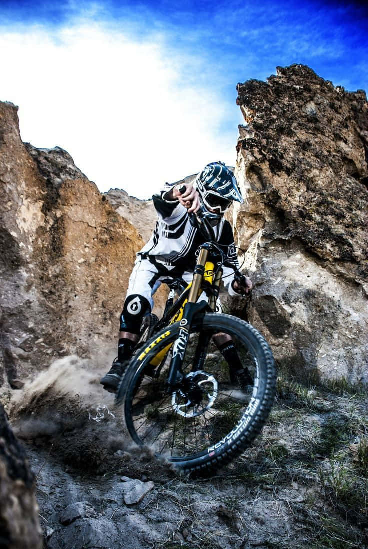 Caption: Adrenaline-packed Mountain Biking Adventure, Viewed From An Iphone Background