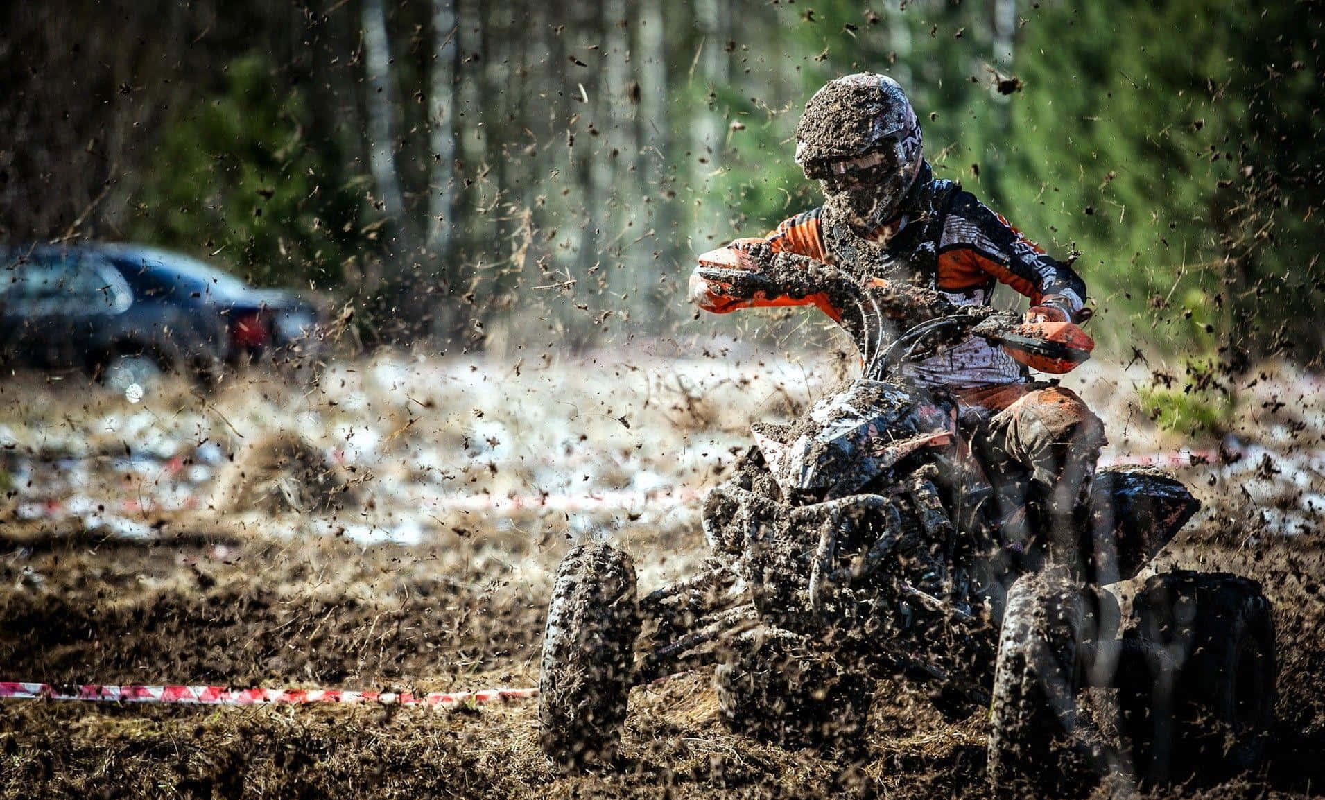 Caption: Adventure Unleashed: Superenduro Atv Diving Into A Muddy Terrain