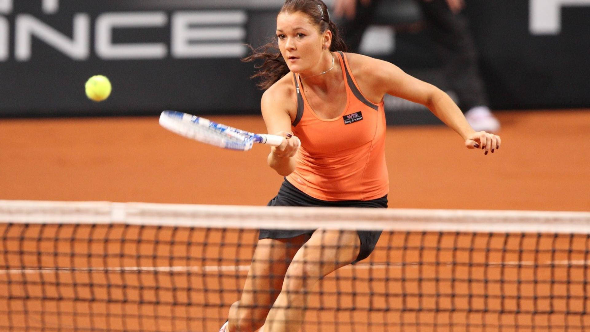 Caption: Agnieszka Radwanska Engrossed In A Tennis Match Background