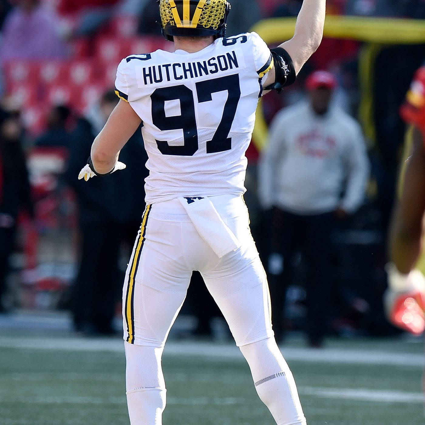 Caption: Aidan Hutchinson In Action For Michigan Wolverines In Ncaa Football Background