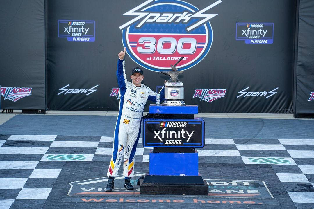 Caption: Aj Allmendinger Celebrating Victory With Trophy Background