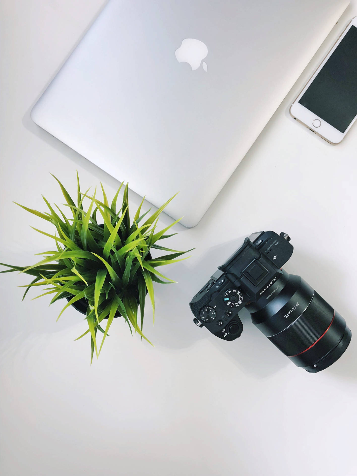 Caption: Apple Devices And Camera On A Wooden Desk