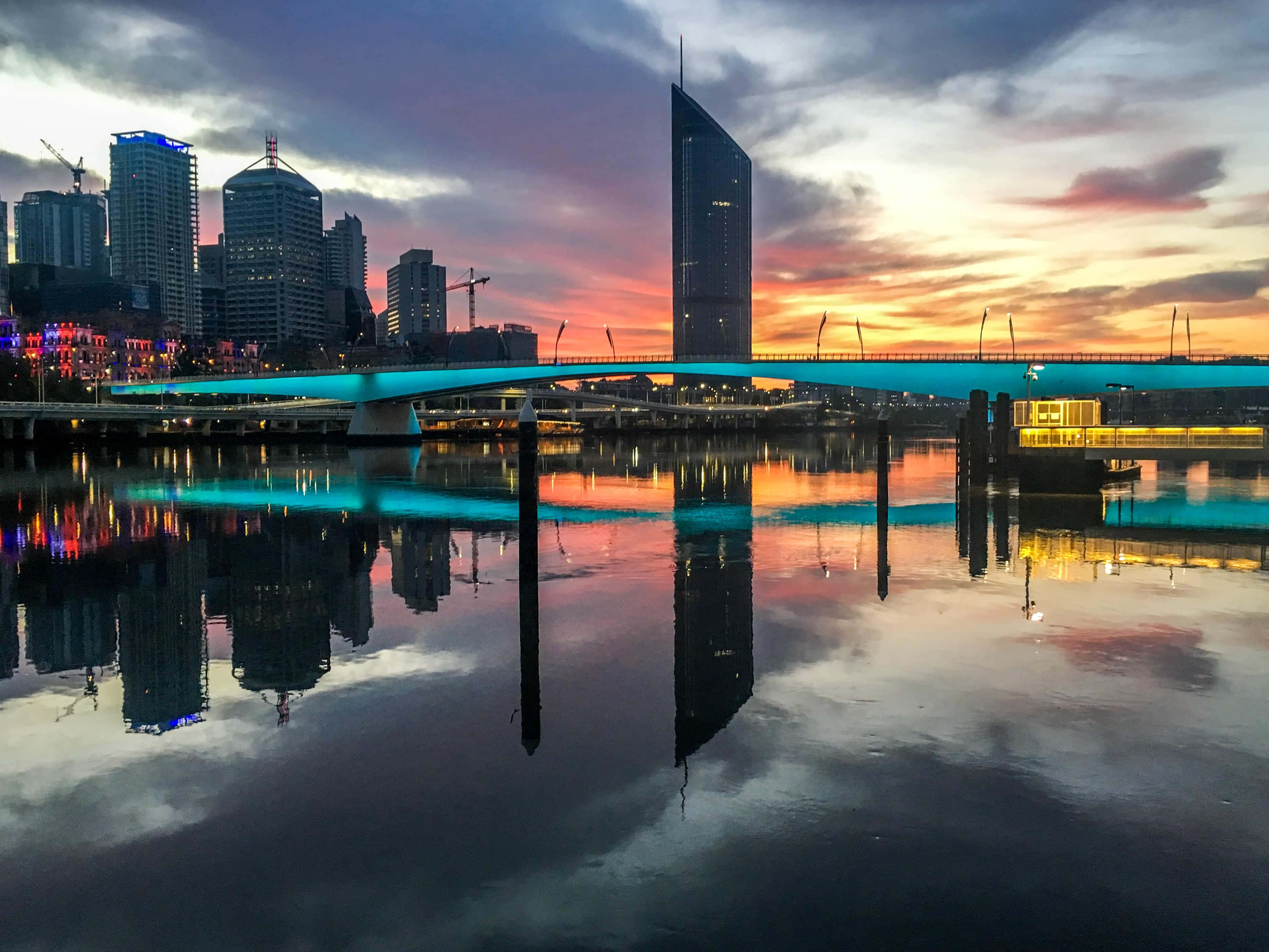 Caption: Astonishing Skyline Of Brisbane At Sunset Background