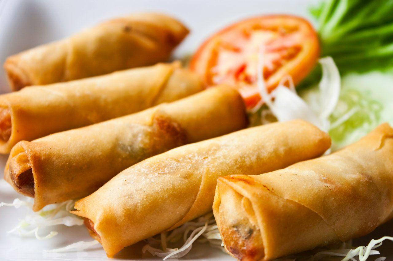 Caption: Authentic Chinese Egg Rolls Artfully Presented With Fresh Vegetables Background