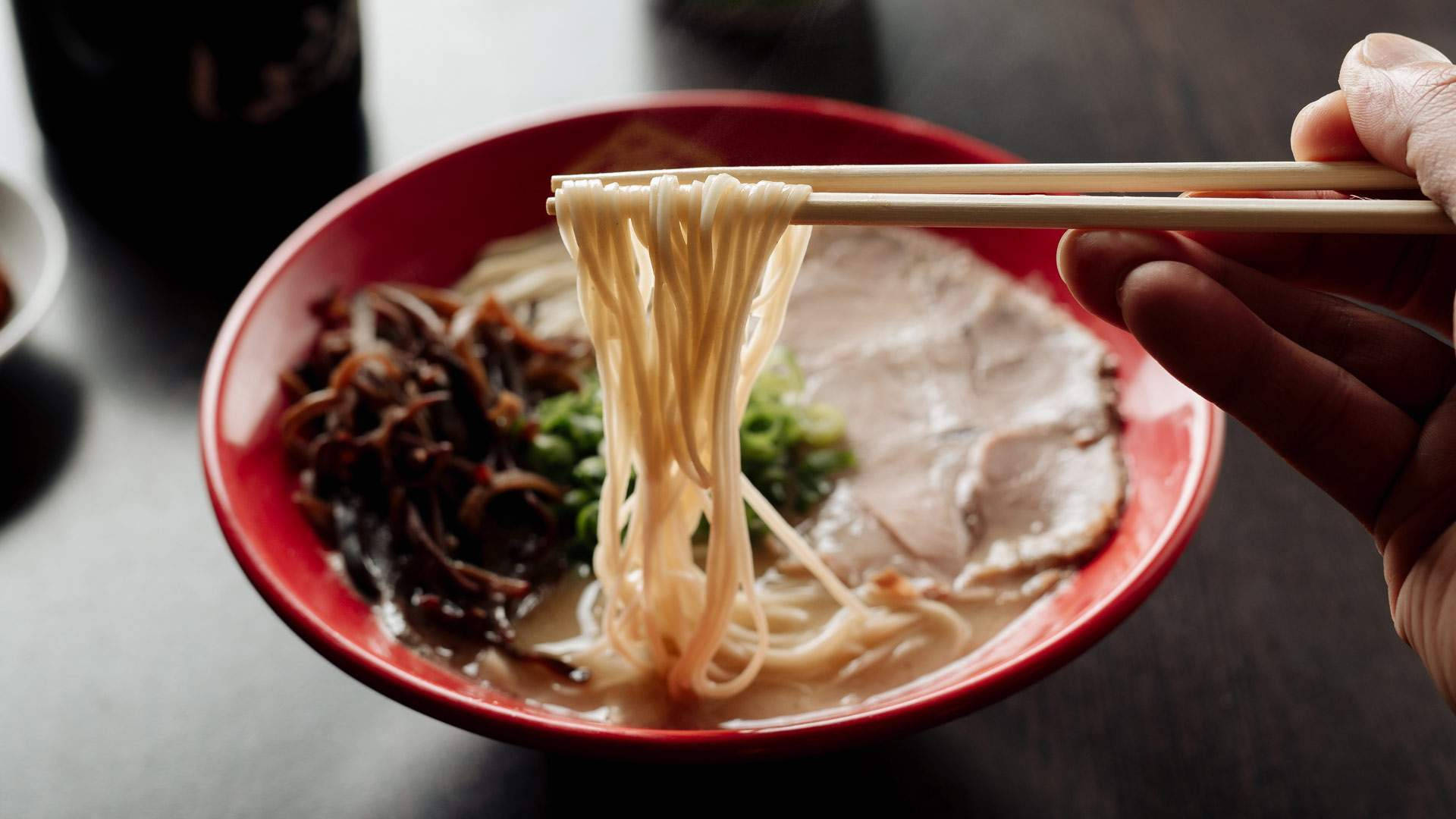 Caption: Authentic Hakata Ramen Served Hot With Chopsticks Background