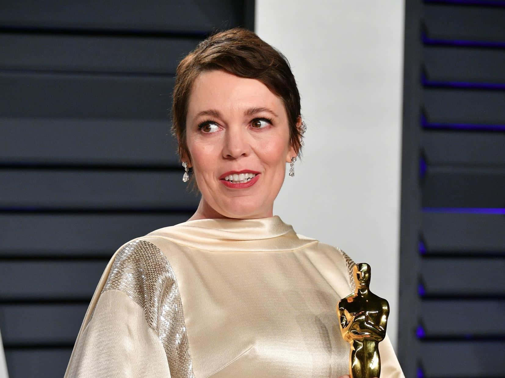 Caption: Award-winning Actress Olivia Colman In An Elegant Gown. Background