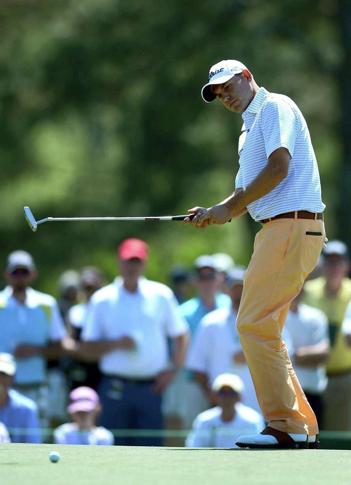 Caption: Bill Haas Focused On The Flying Golf Ball Background