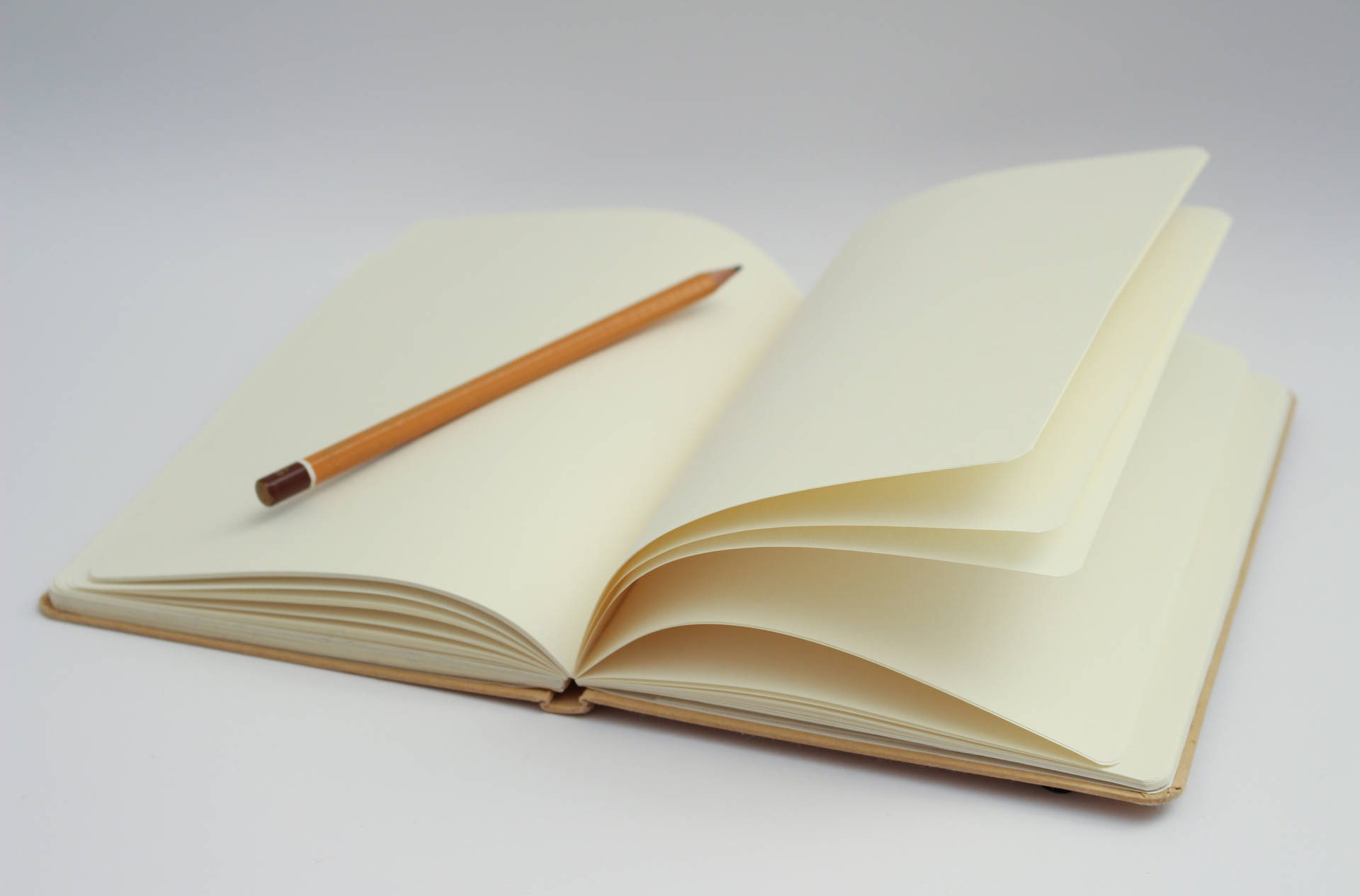 Caption: Blank Journal With Pencil Ready For Idea Generation Background