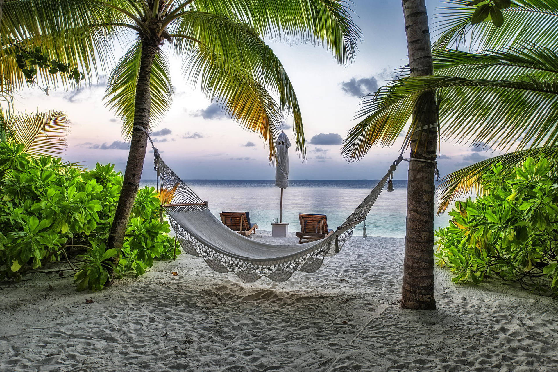 Caption: Captivating Maldives Beach With A Comfortable Hammock Background