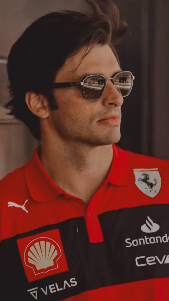 Caption: Carlos Sainz Jr. Poses In His Signature Sunglasses Background