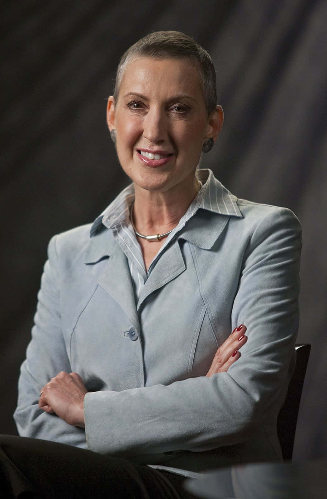 Caption: Carly Fiorina Displaying Leadership With Crossed Arms Background