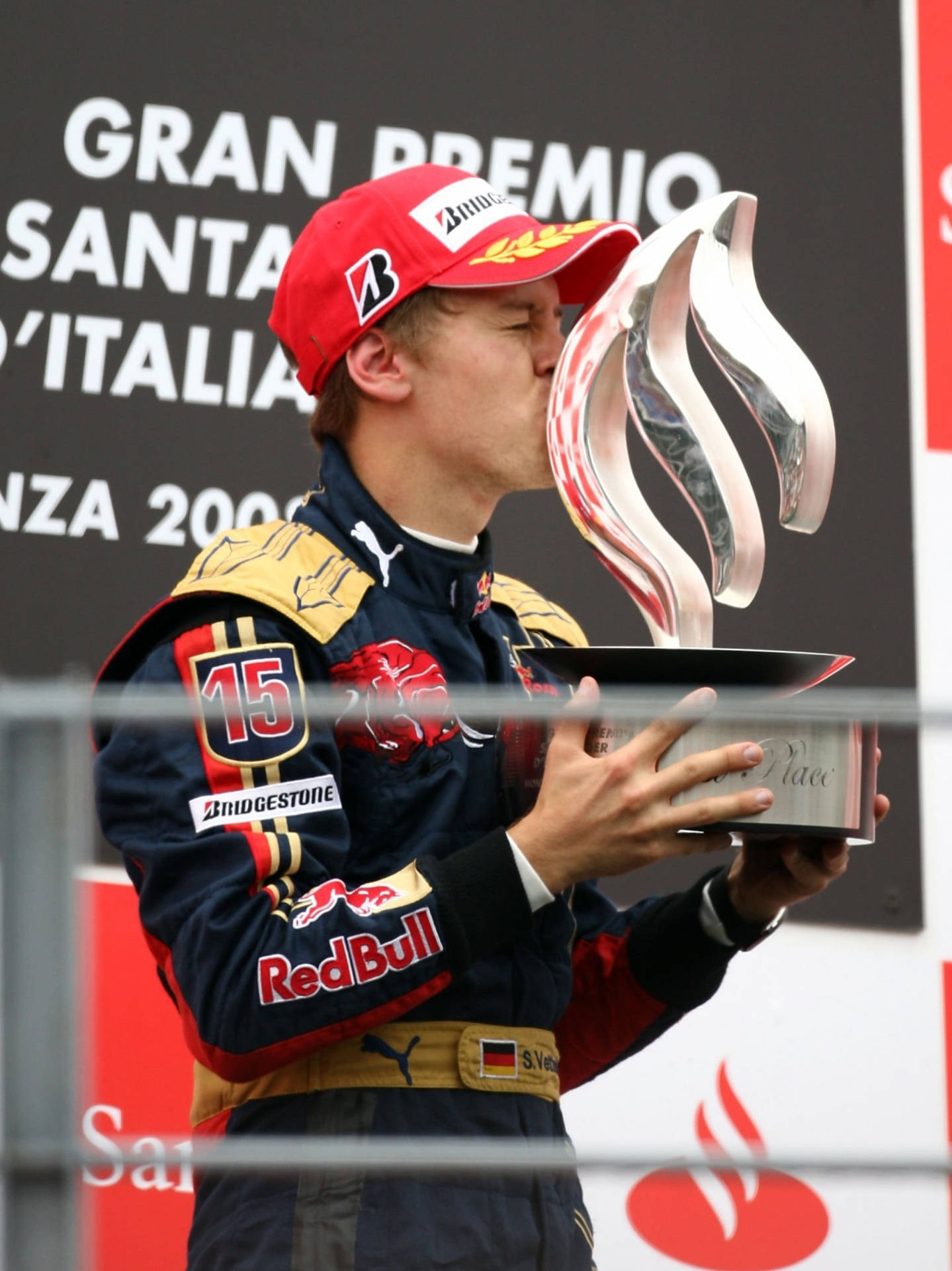 Caption: Celebrated F1 Racer, Sebastian Vettel, Kissing His Coveted Trophy Background