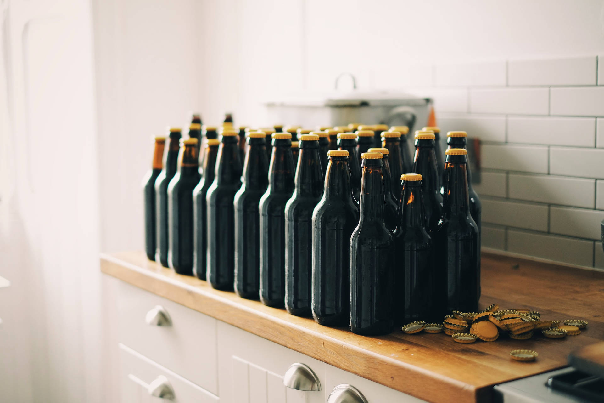 Caption: Chilled Beer Bottles With Yellow Crowns Background