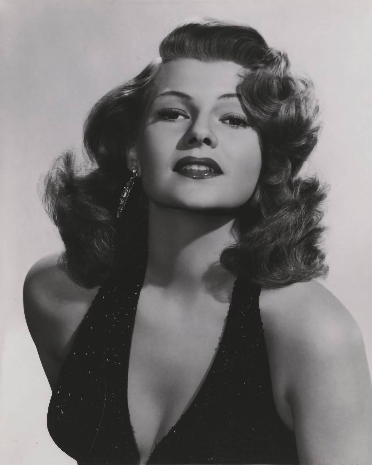 Caption: Classic Hollywood Icon Rita Hayworth In Sparkling Halter Dress Background