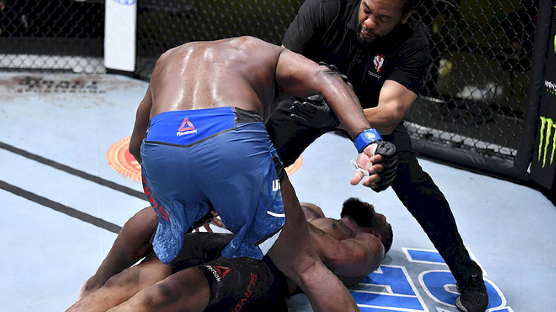 Caption: Curtis Blaydes Demonstrating Strength Against An Opponent In The Ring Background