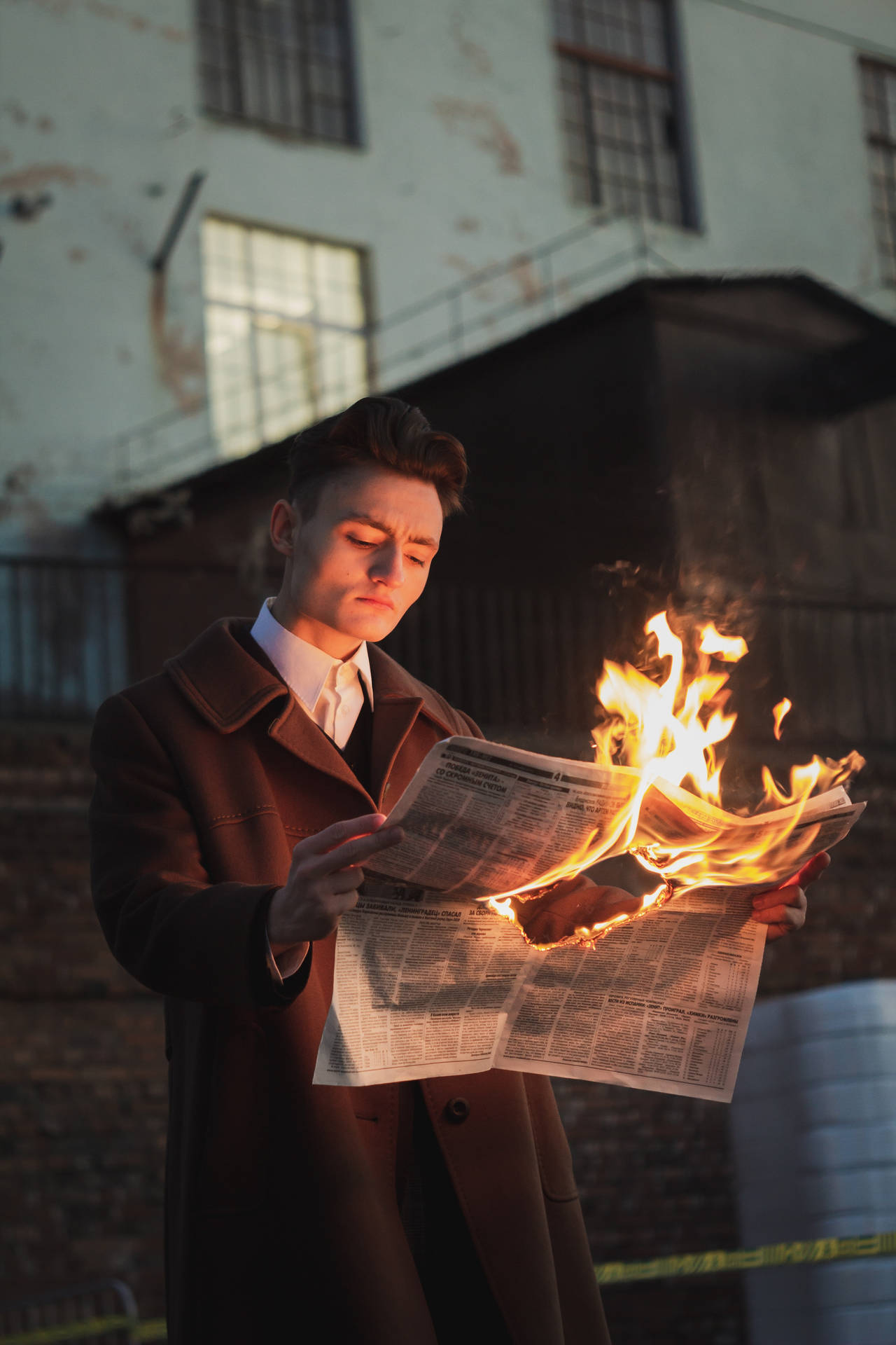 Caption: Daring Stylish Man Holding A Burning Newspaper