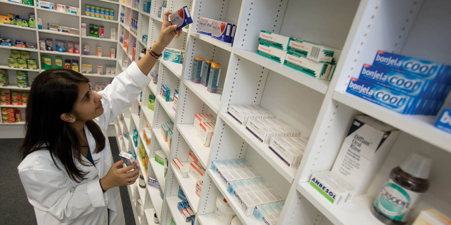 Caption: Dedicated Female Pharmacist Engaged In Medicine Check