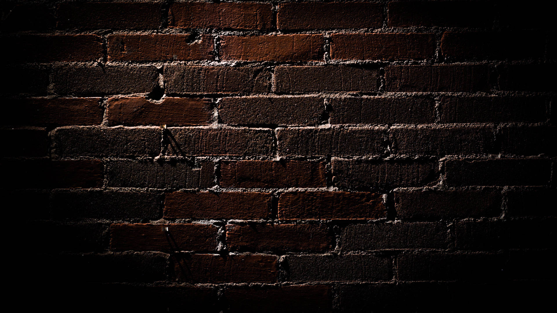 Caption: Deep Brown Brick Texture Under Dim Light Background