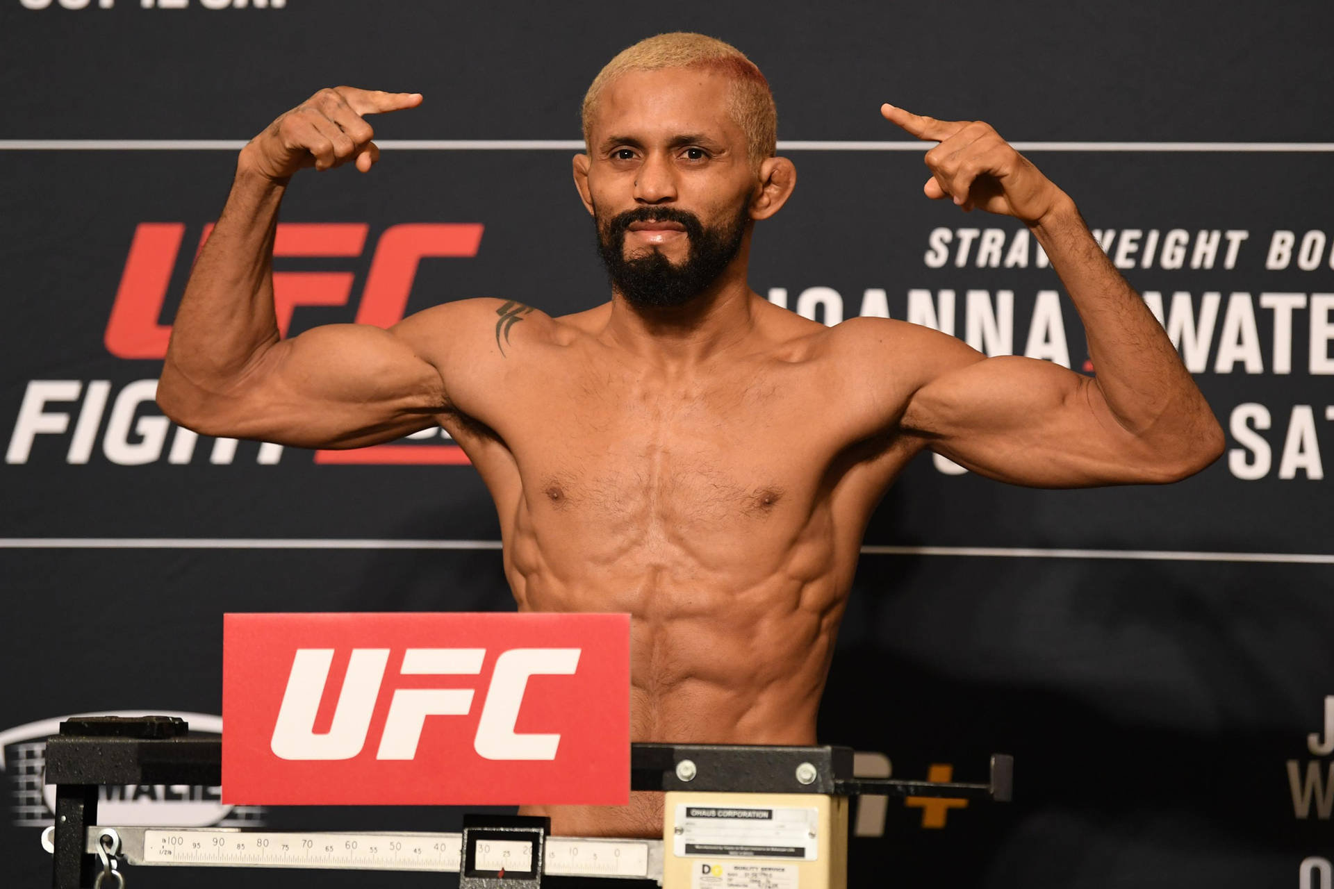 Caption: Deiveson Figueiredo Powerfully Posing In Mma Ring Background